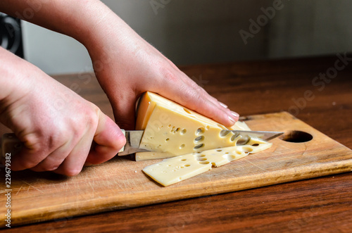 Slicing cheese on a wooden board.