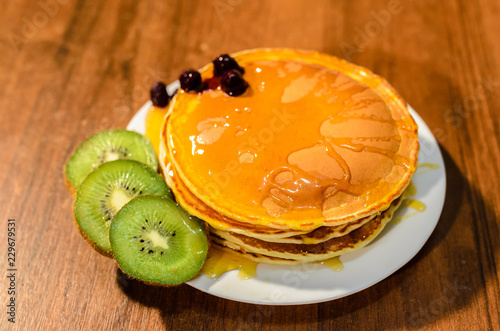 Delicious pancakes with honey, kiwi and berries. photo