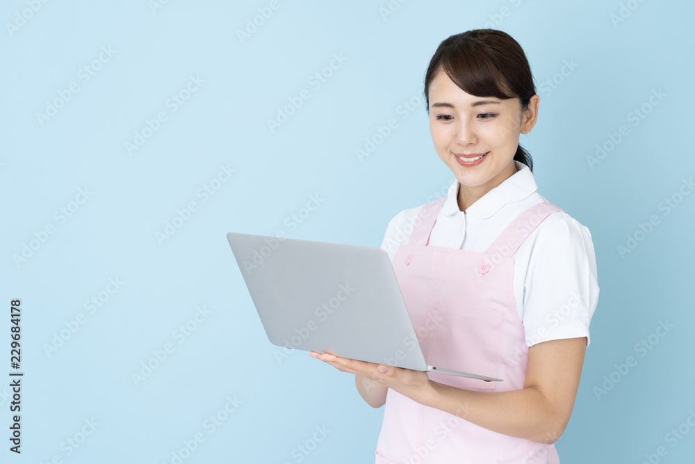 portrait of young asian nurse wearing apron on blue background portrait of young asian nurse wearing apron on blue background