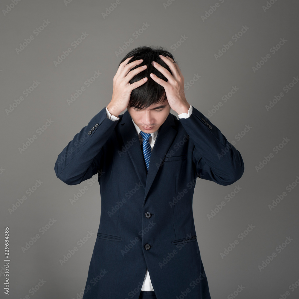 Business man is headache ,grey background in studio Business man is headache ,grey background in studio