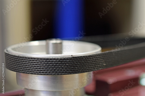 Close up of pulley and belt drive of bench drilling machine. Copy space. Shallow depth of field.