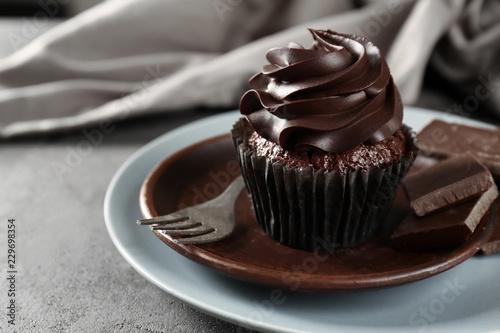 Delicious chocolate cupcake on plate, closeup