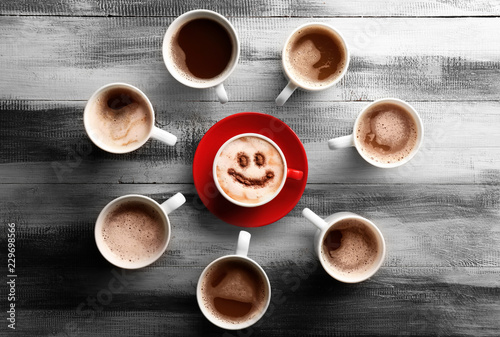 Many cups with tasty aromatic coffee on wooden table, flat lay