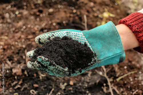Woman holding black soil ou...