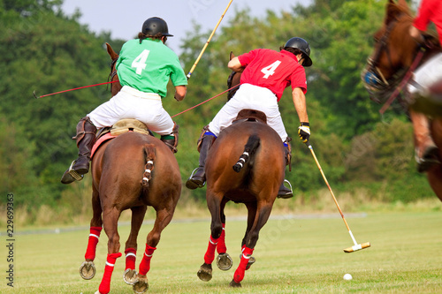 Polo players, riding hard and competing for ball