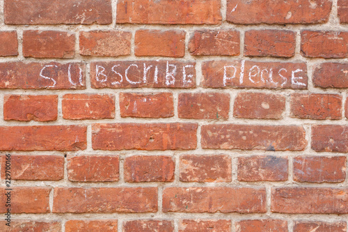 Text subscribe please on old vintage brick wall texture