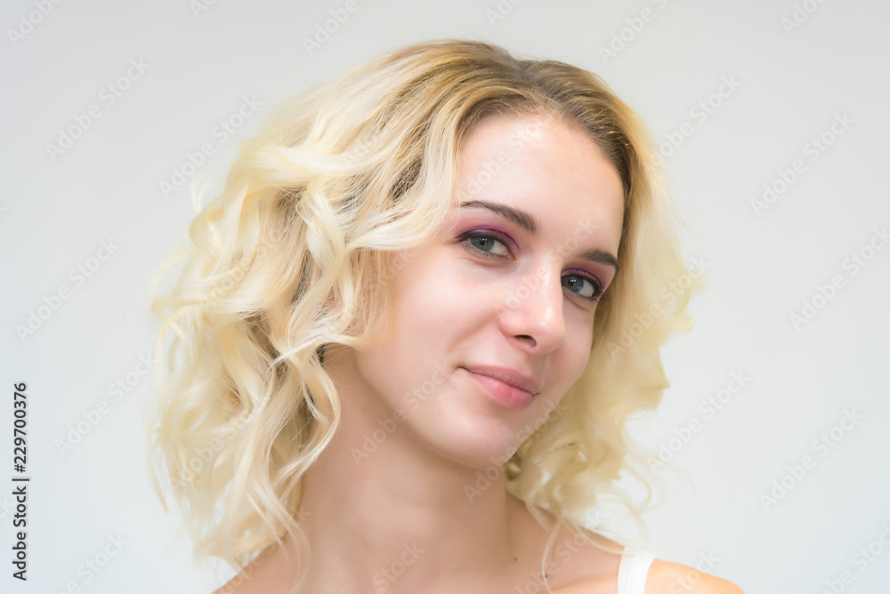 Beauty portrait of a beautiful blonde girl on a white background with perfect makeup.