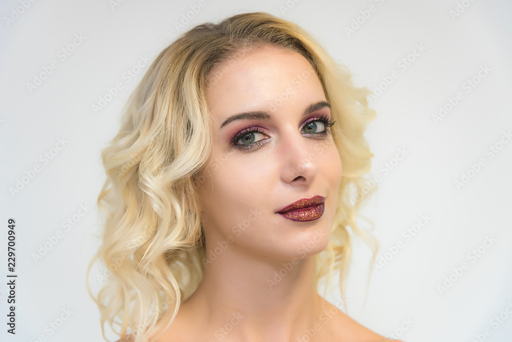 Beauty portrait of a beautiful blonde girl on a white background with perfect makeup. Beauty portrait of a beautiful blonde girl on a white background with perfect makeup.