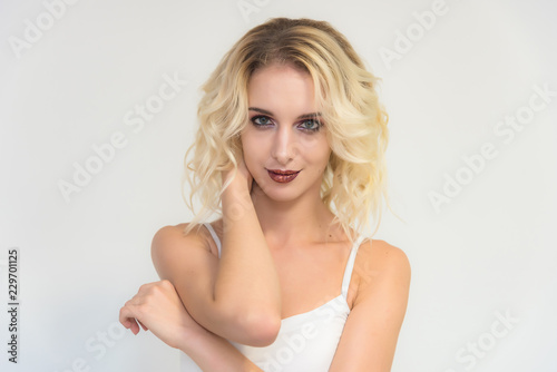 Beauty portrait of a beautiful blonde girl on a white background with perfect makeup.