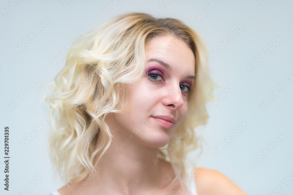 Portrait of a beautiful blonde girl while working as a professional beautician make-up artist.