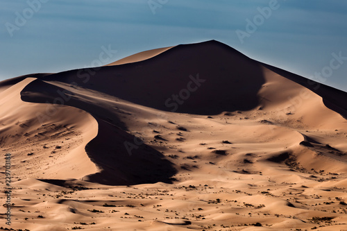 View of sand dunes against blue sky