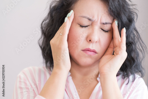 Asian woman headache in the living room sofa