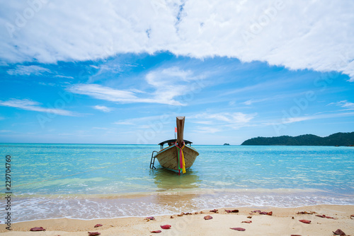 summer beach and long tail traditional thai boat, sea and sky background