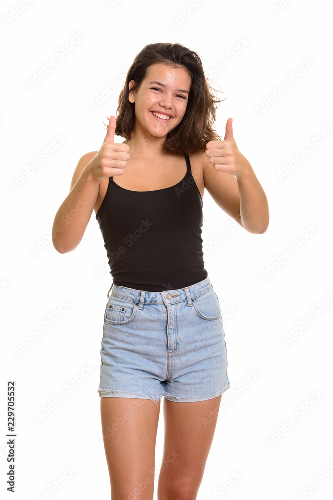 Young happy Caucasian teenage girl smiling and giving thumbs up 