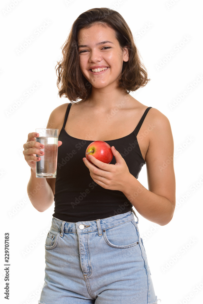 Young happy Caucasian teenage girl smiling while holding glass o Young happy Caucasian teenage girl smiling while holding glass o