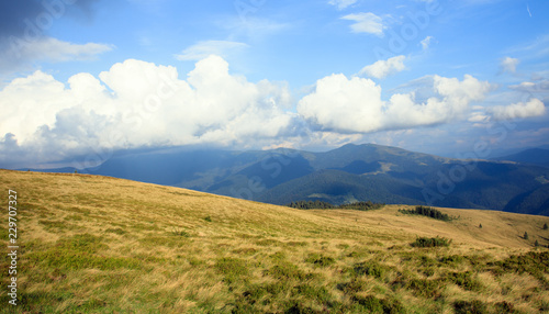 big white clouds in the mountains on the peak, yellow grass, scenery view