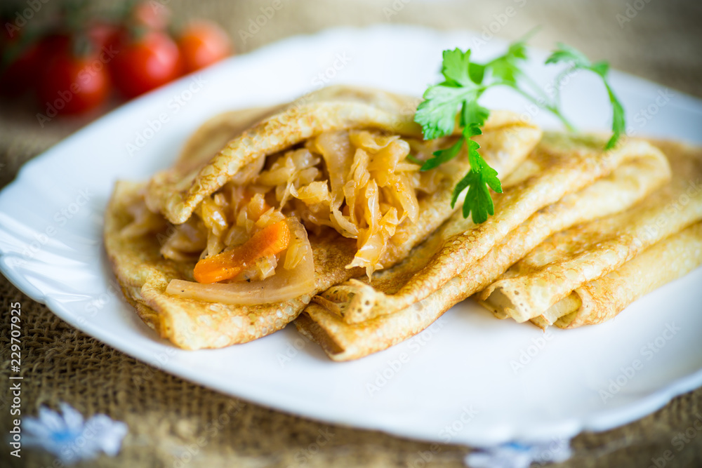 thin fried pancakes stuffed with stewed cabbage in a plate thin fried pancakes stuffed with stewed cabbage in a plate