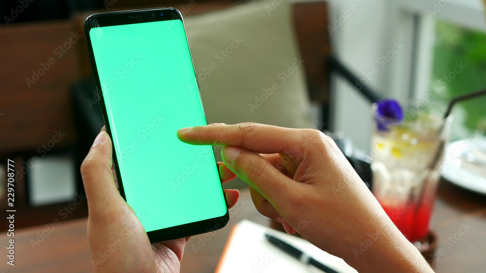 woman hand holding mobile smart phone with blank green screen, use ...