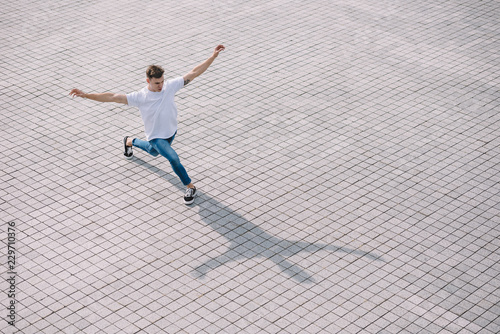 high angle view of handsome young man performing contemporary dance on street