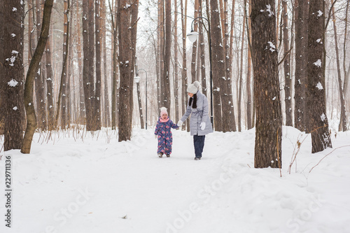 Motherhood, children and nature concept - Attractive young woman and adorable child walking in park © satura_