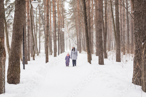 Motherhood, children and nature concept - Attractive young woman and adorable child walking in park