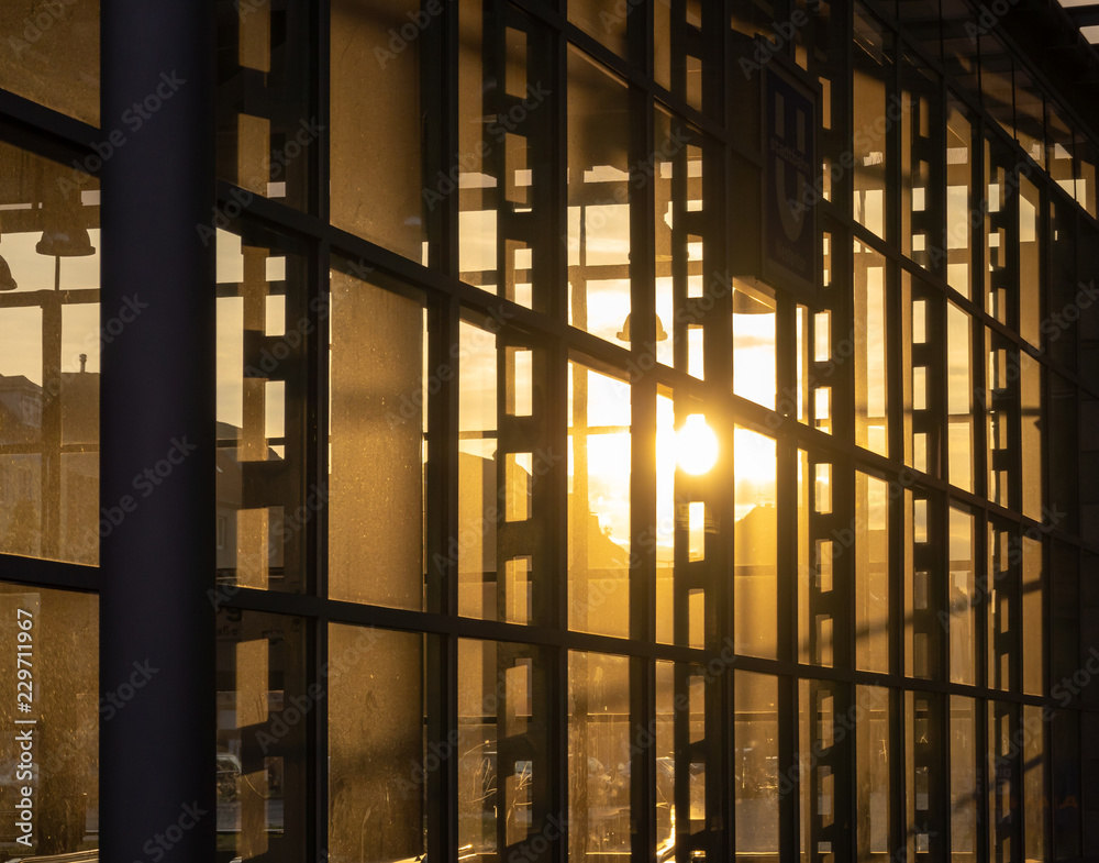 Reflection of the setting sun in the fully glazed facade of a high-rise building. Reflection of the setting sun in the fully glazed facade of a high-rise building.