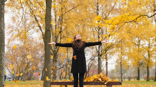 Woman through fallen golden leaves photo