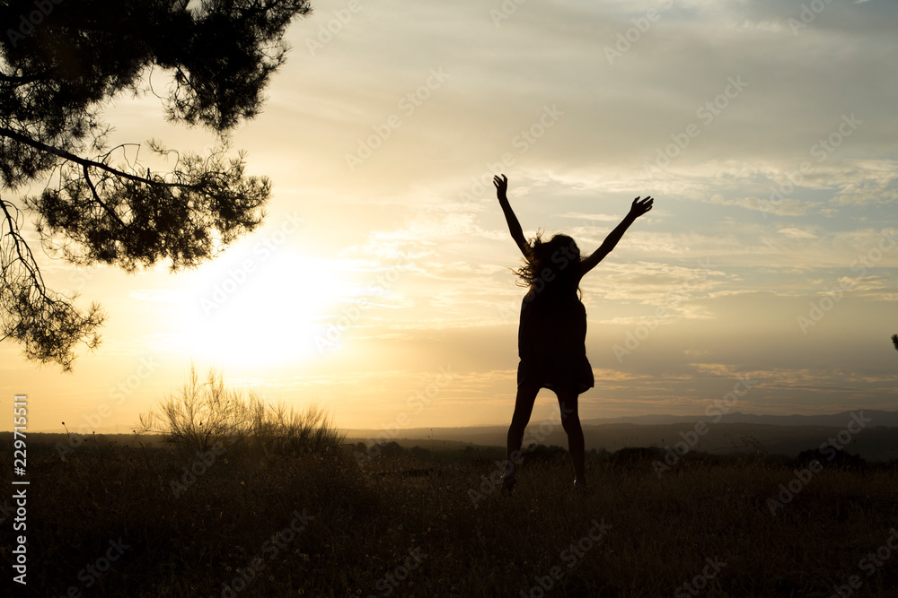 Backlight of a mother and daughter in a pine forest with yellow sky 