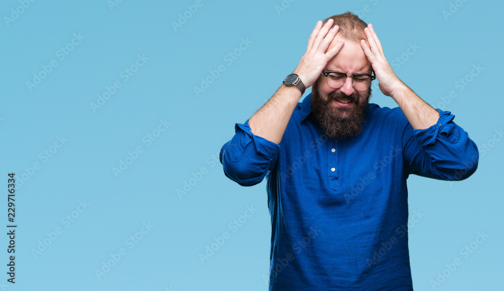Naklejka premium Young caucasian hipster man wearing glasses over isolated background suffering from headache desperate and stressed because pain and migraine. Hands on head.