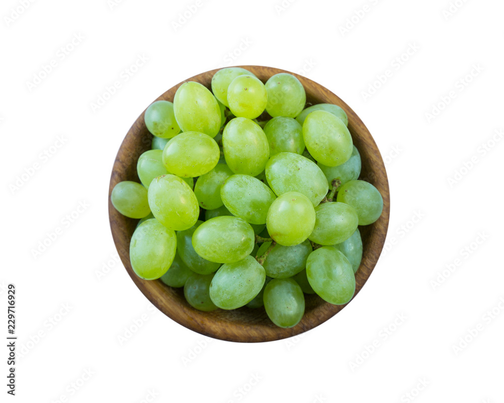 Grapes in a wooden bowl isolated on white background. Green grapes Kish Mish. Vegetarian or healthy eating. Top view.