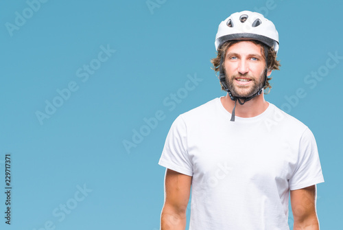 Handsome hispanic cyclist man wearing safety helmet over isolated background with a happy and cool smile on face. Lucky person.