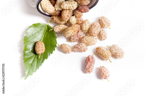 White cup with white mulberry fruit and leaf isolated on white. photo