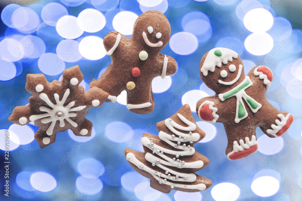Fototapeta premium Gingerbread on blue christmas lights background. The concept of celebrating Christmas and New Year.