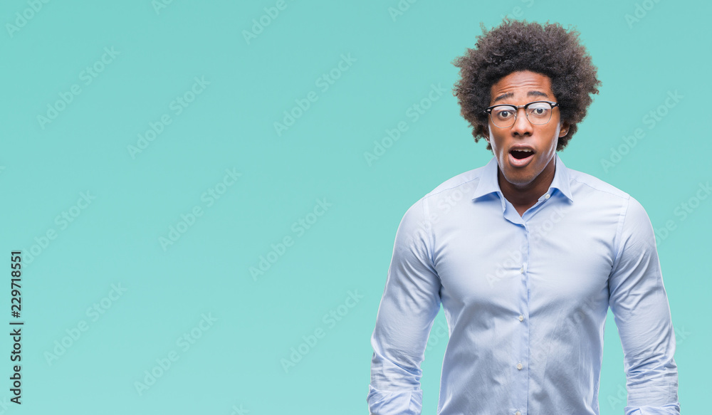 Obraz premium Afro american business man wearing glasses over isolated background afraid and shocked with surprise expression, fear and excited face.