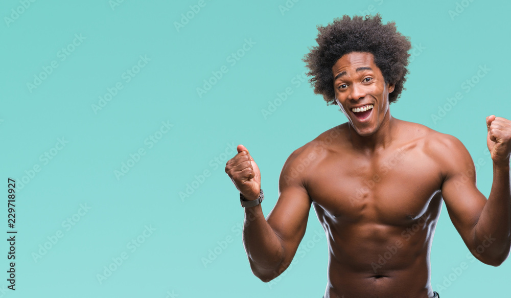 Afro american shirtless man showing nude body over isolated background celebrating surprised and amazed for success with arms raised and open eyes. Winner concept.