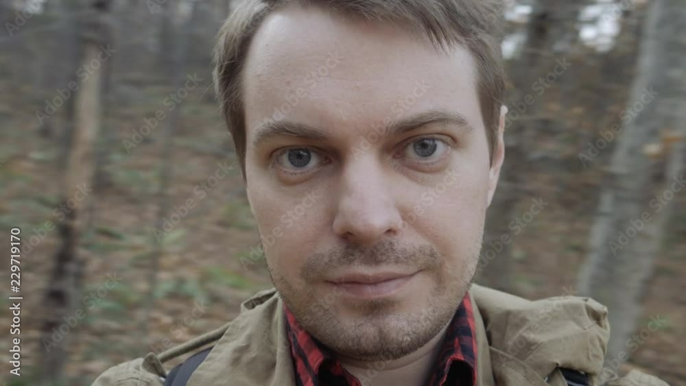 The young man filming himself in the forest during autumn. The young man filming himself in the forest during autumn.