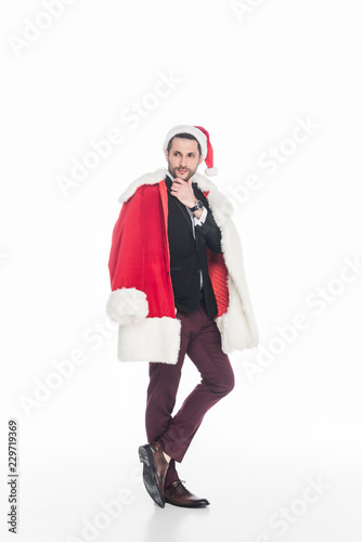 pensive man in santa claus costume looking away isolated on white