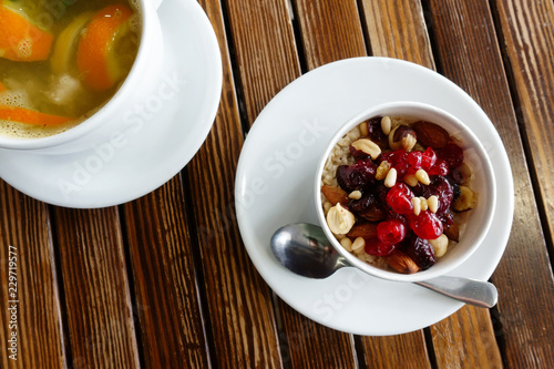 healthy breakfast: oatmeal with dried fruits, nuts and honey and a cup of hot citrus tea