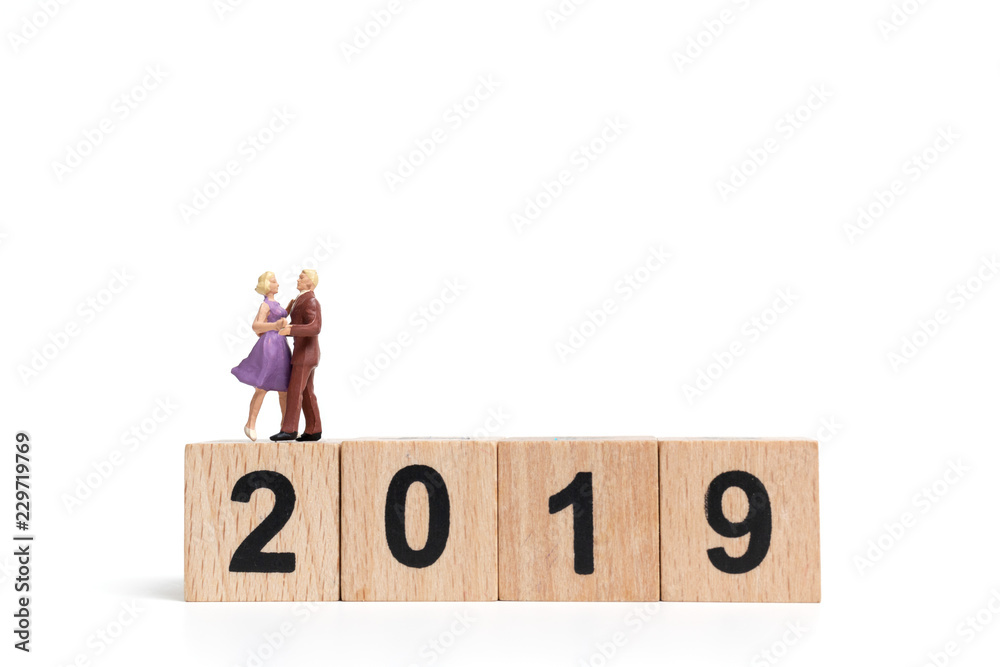 Miniature people dancing on wooden block number 2019. Miniature people dancing on wooden block number 2019.