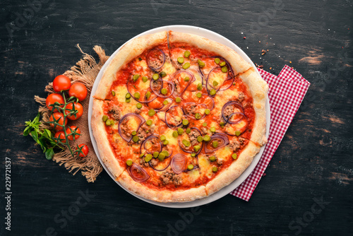 Pizza with tuna and onion. Italian traditional dish. On the old background. Top view. Free space for your text.
