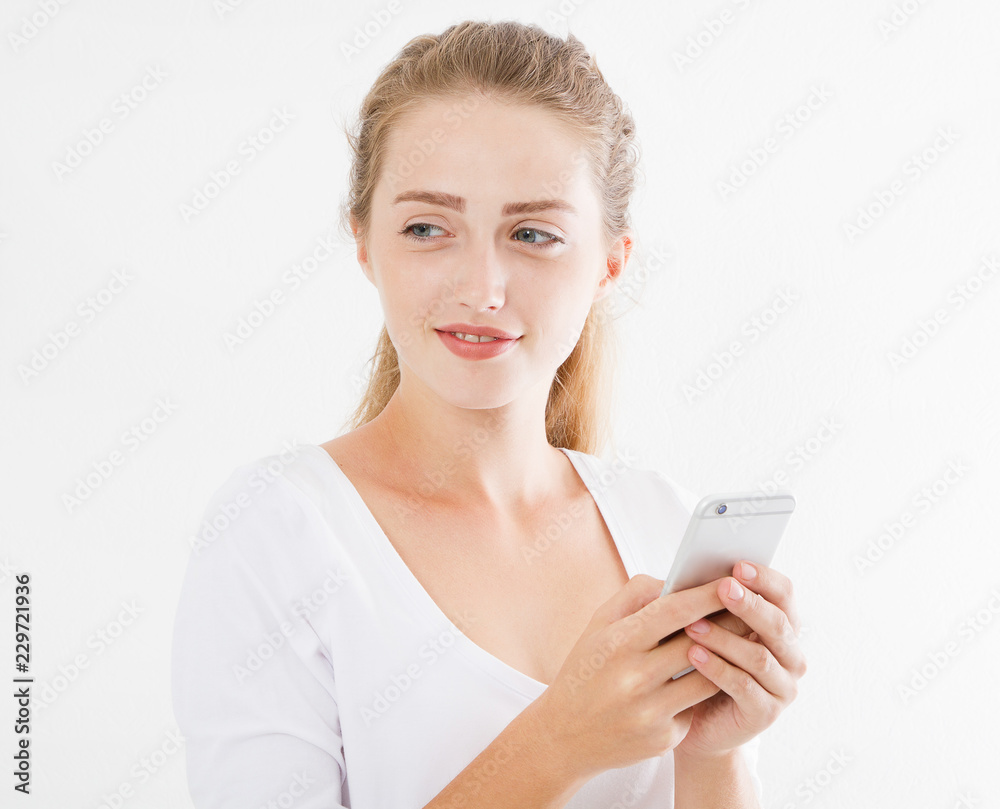 Portrait of a smiling young woman holding mobile phone isolated on white background, chatting girl,advertising concept,copy space Portrait of a smiling young woman holding mobile phone isolated on white background, chatting girl,advertising concept,copy space