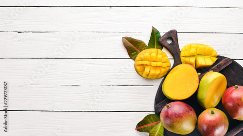 Mango. On a white wooden background. Tropical Fruits. Top view. Free copy space.