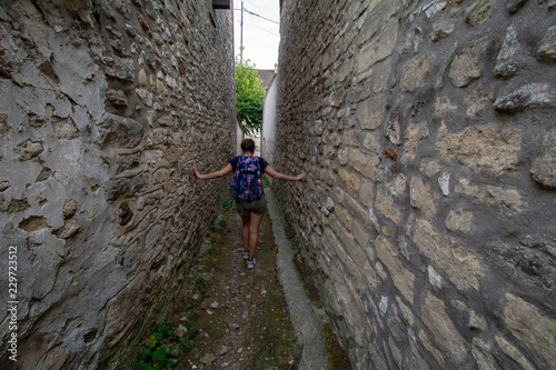 Person walking through alley in French village