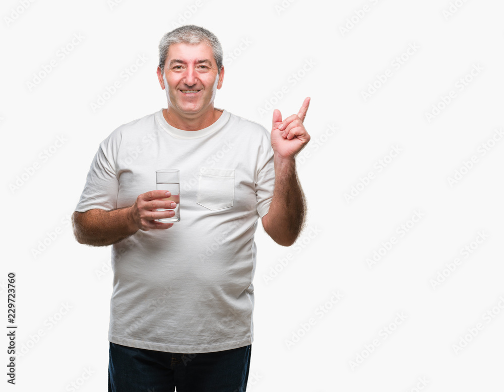 Handsome senior man drinking glass of water over isolated background very happy pointing with hand and finger to the side