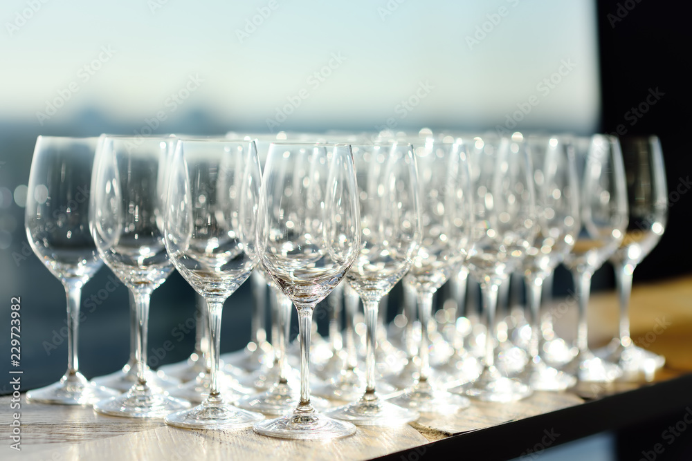 Lots of crystal clear empty wine glasses at the bar.