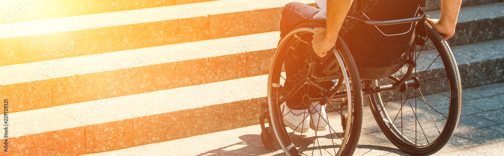 cropped image of disabled man using wheelchair on street and stopping near stairs without ramp - obrazy, fototapety, plakaty 