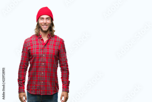 Young handsome man with long hair wearing red cap over isolated background with a happy and cool smile on face. Lucky person.