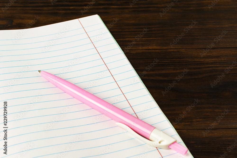 Education concept back to school - pink pen on book background close-up, mock-up, copy space Education concept back to school - pink pen on book background close-up, mock-up, copy space