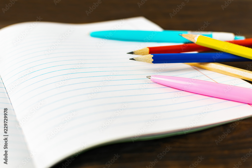 Back to school and education concept - blank note paper with pens and pencils on wooden background. Copy space. Back to school and education concept - blank note paper with pens and pencils on wooden background. Copy space.
