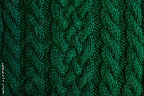 Texture of warm green knitted winter clothes.